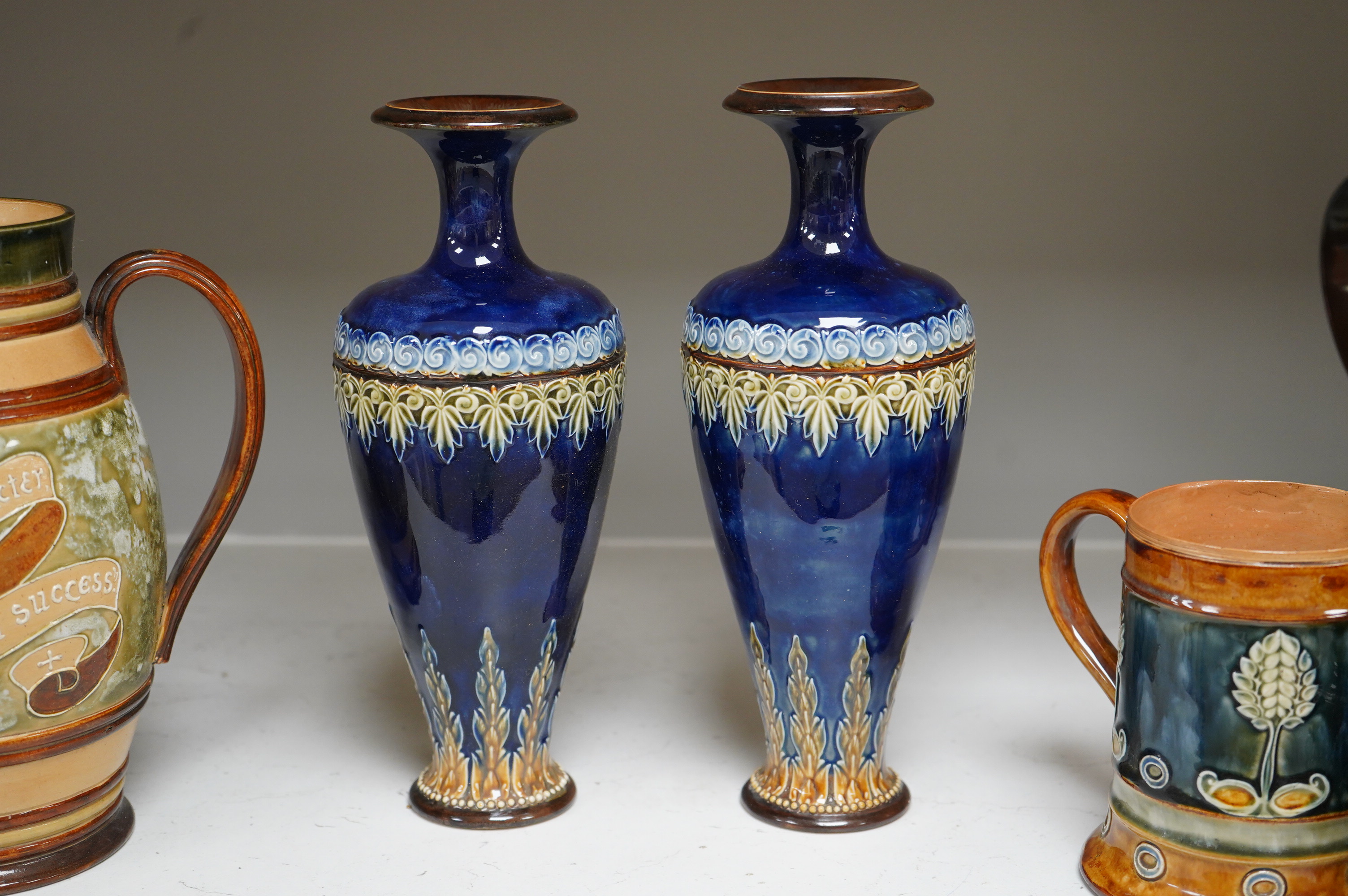 A Doulton Lambeth stoneware commemorative pitcher of William Ewart Gladstone 23cm high, together with a pair of vases two handled vase and a mug, (5).